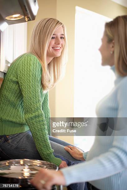 mother cooking dinner and chatting with her daughter - 16 17 girl blond hair stock pictures, royalty-free photos & images