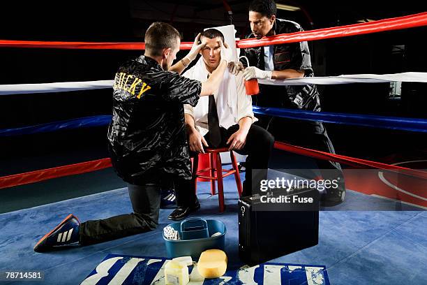 businessman boxer being treated between rounds - boxing corner stock pictures, royalty-free photos & images