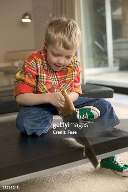 boy sawing wooden table in living room - pants pulled down stock pictures, royalty-free photos & images