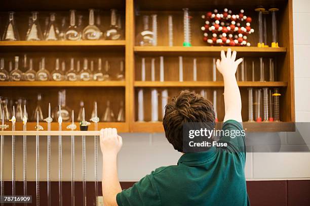 teenage boy reaching for molecule model - geology class stock pictures, royalty-free photos & images