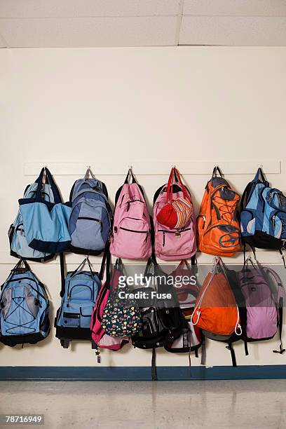 school backpacks hanging on wall hooks - coat stand stock pictures, royalty-free photos & images