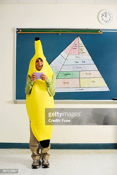 student in banana suit giving class presentation on nutrition - 三角錐 ストックフォトと画像