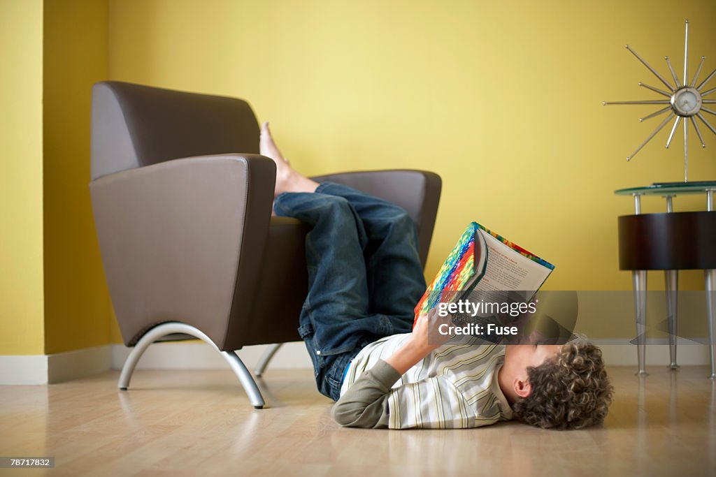 Boy Reading Book with Feet Up