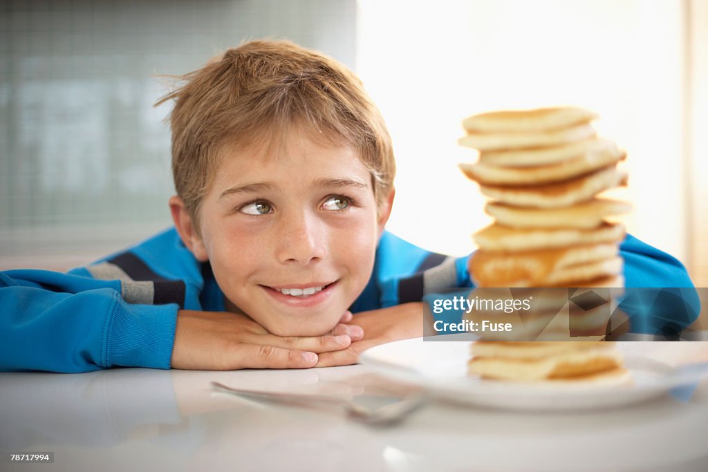 Boy Staring at Stack of Pancakes