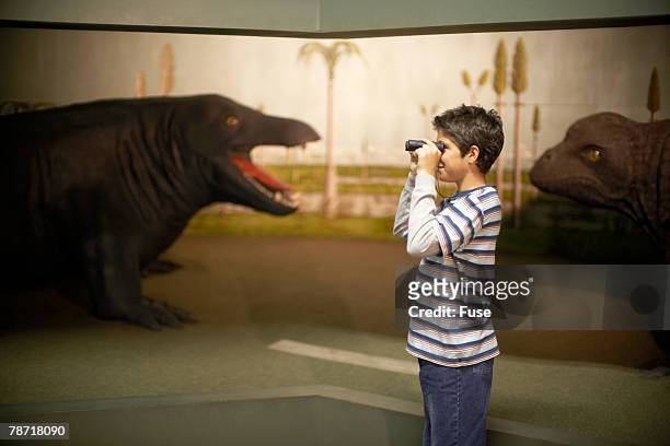 boy playing with binoculars in museum - natural history museum stock pictures, royalty-free photos & images