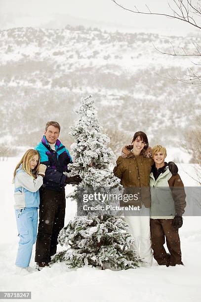 family standing outside with christmas tree - traditional parka stock pictures, royalty-free photos & images
