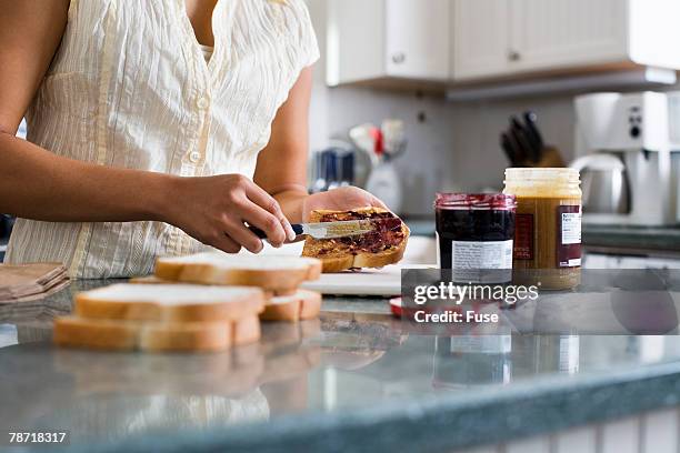 woman making sandwiches - marmelade machen stock-fotos und bilder