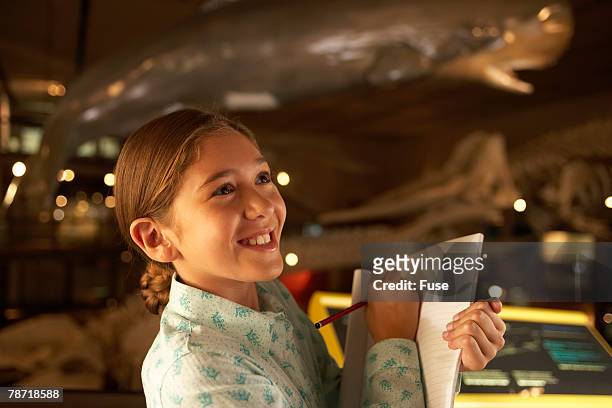 young girl taking notes in a museum - museo de historia natural fotografías e imágenes de stock