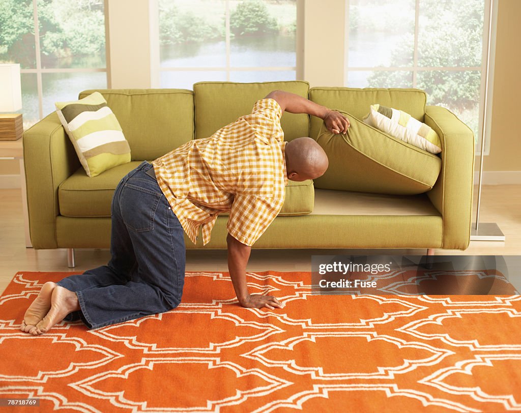 Man Searching Under the Couch Cushions