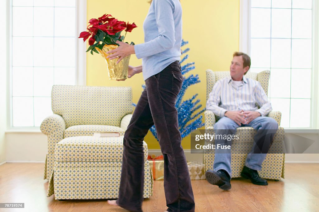 Man Watching Woman Place Poinsettia