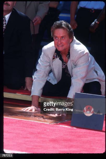 Michael Douglas puts his hands into wet cement September 10, 1997 in Los Angeles, CA. Actors Kirk and Michael Douglas are the first father-and-son...