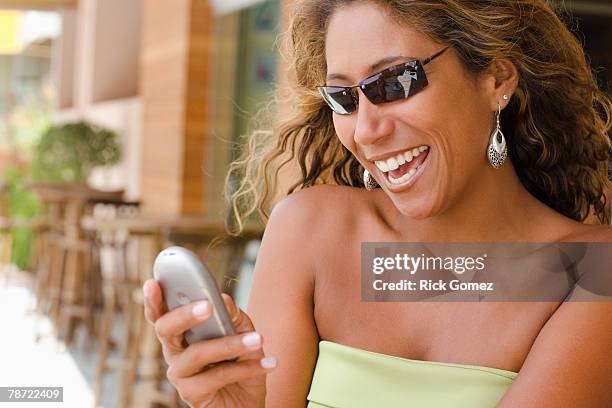 laughing woman with cell phone - esperanza gomez fotografías e imágenes de stock