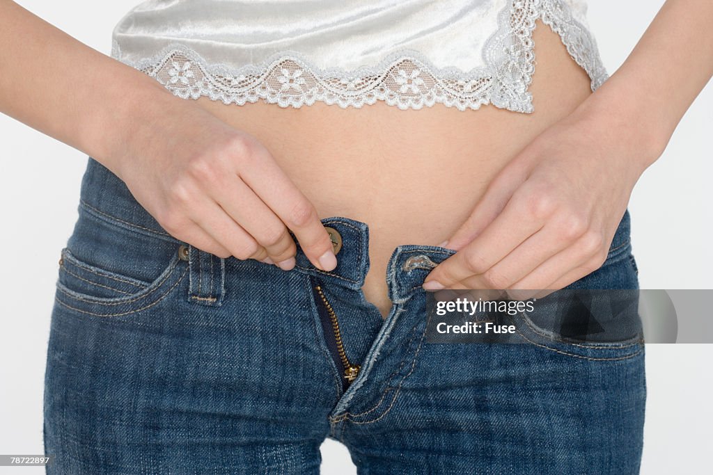Woman Buttoning Pants