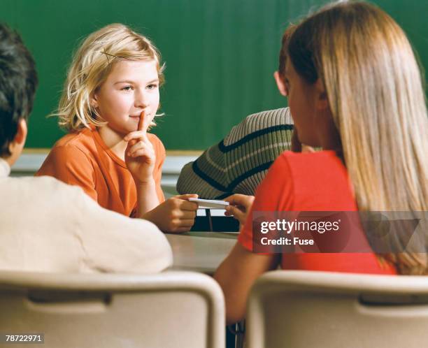 schoolgirls passing notes in class - kids passing notes stock pictures, royalty-free photos & images