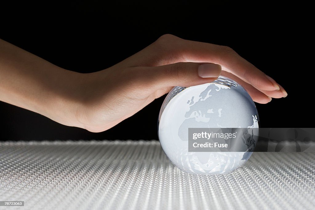Hand Covering Glass Globe