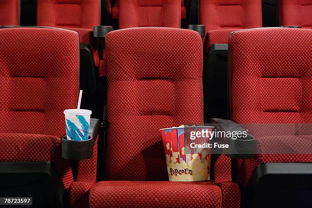 popcorn and soft drink in empty seat at the movie theater - soft drink stock-fotos und bilder