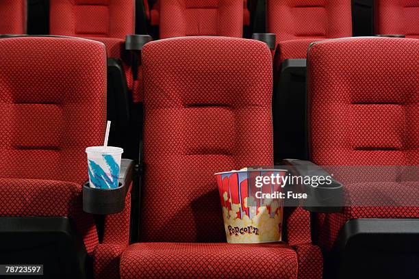 popcorn and soft drink in empty seat at the movie theater - cinema seats stockfoto's en -beelden