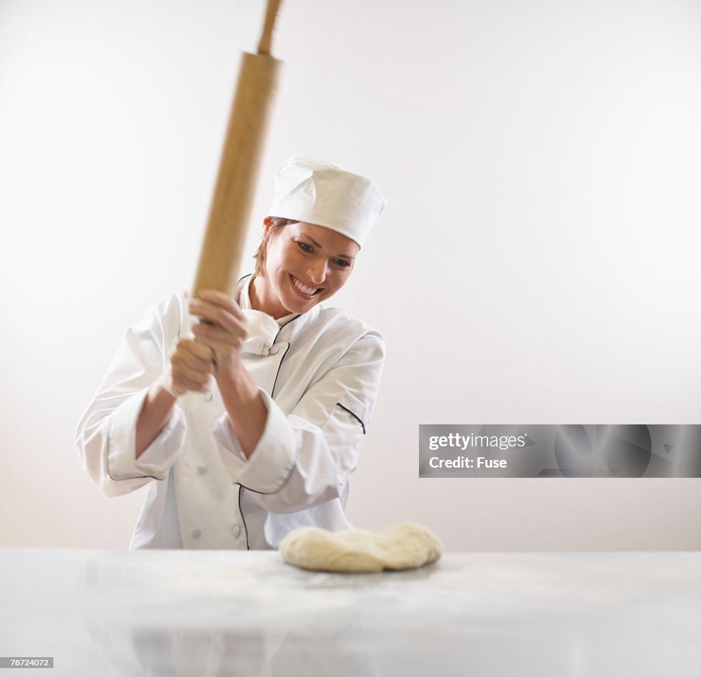 Baker About to Pound Dough with Rolling Pin