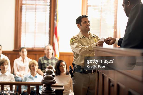 judge handing bailiff a piece of paper - bailiff stock pictures, royalty-free photos & images