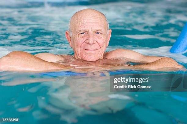 senior man in swimming pool - hallenbad leer stock-fotos und bilder