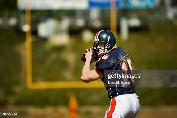 quarterback going back to pass - quarterback throwing stock pictures, royalty-free photos & images