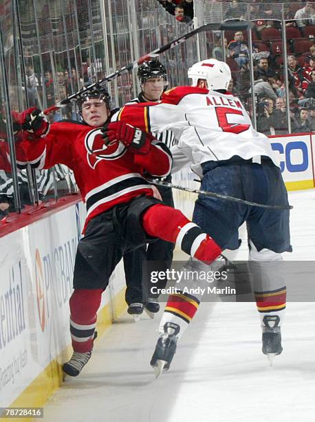 Bryan Allen of the Florida Panthers checks Zach Parise of the New Jersey Devils high and hard during their game at the Prudential Center on January...