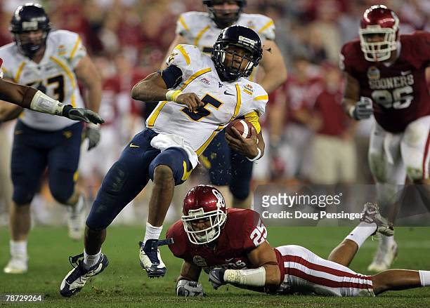 Quarterback Patrick White of the West Virginia Mountaineers runs for seven-yards past D.J. Wolfe of the Oklahoma Sooners in the second half at the...