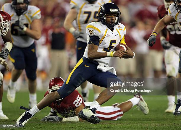 Quarterback Patrick White of the West Virginia Mountaineers runs for seven-yards past D.J. Wolfe of the Oklahoma Sooners in the second half at the...