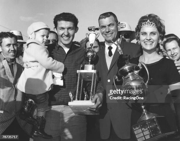 Richard Petty holds his infant son, Kyle, after winning the Gwyn Staley Memorial 250 at North Wilkesboro Speedway in 1962. Making the presentation...