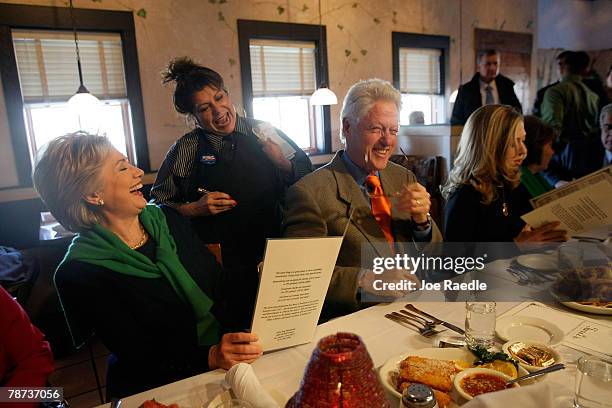 Democratic presidential candidate Sen. Hillary Clinton and her husband former U.S. President Bill Clinton laugh with waitress, Dawny Valdez, as they...