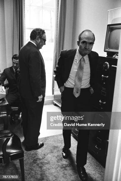 Secretary of State Henry Kissinger, Deputy National Security Advisor Brent Scowcroft, and National Security Council staffer Bud McFarlane await news...