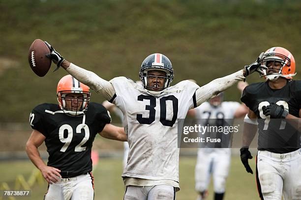 running back scoring touchdown - black man running back stock pictures, royalty-free photos & images