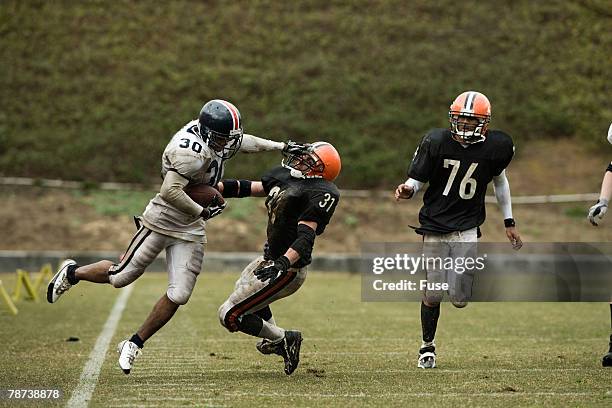 running back breaking a tackle - black man running back stock pictures, royalty-free photos & images