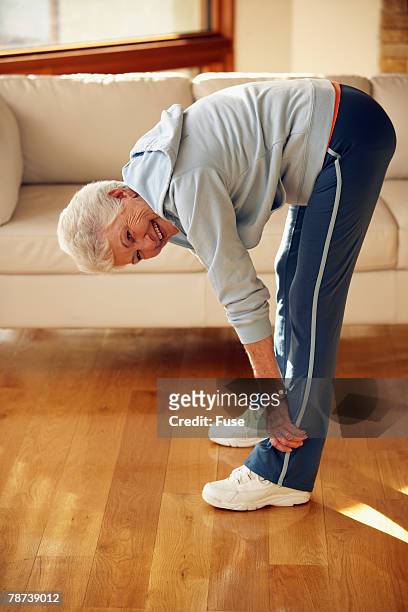 senior woman stretching - zehenspitzen berühren stock-fotos und bilder