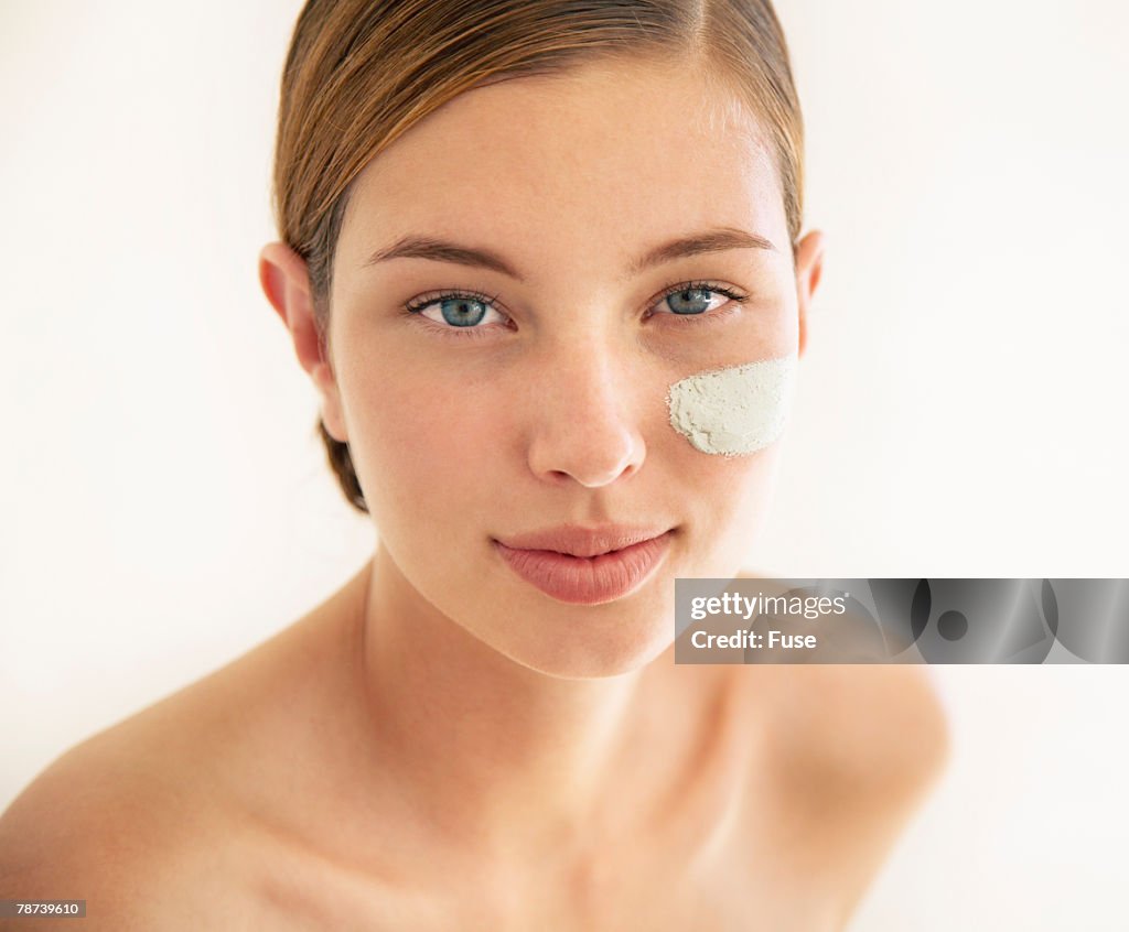 Pretty Young Woman with Face Cream on Cheek