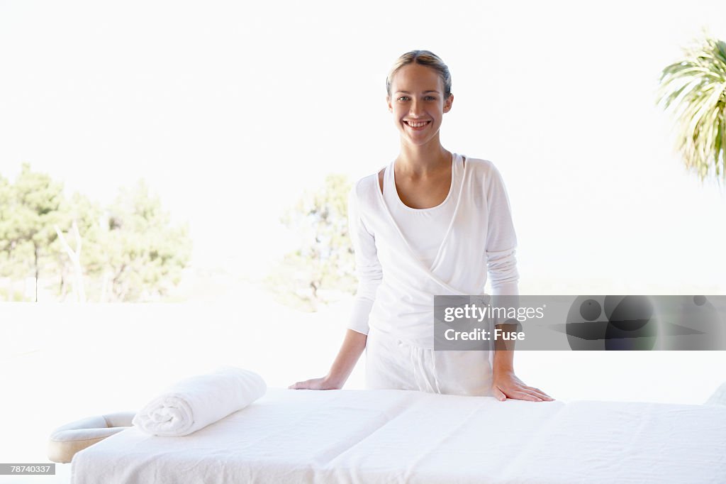 Smiling Massage Therapist at Massage Table