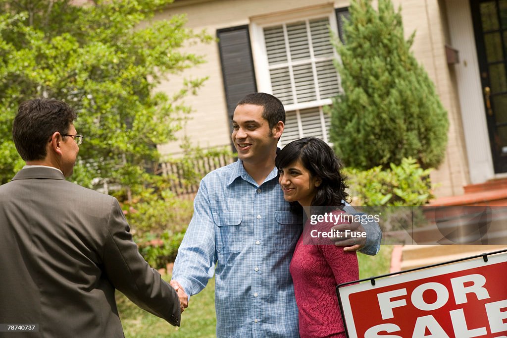 Home Owners Giving a Handshake to the Real Estate Agent