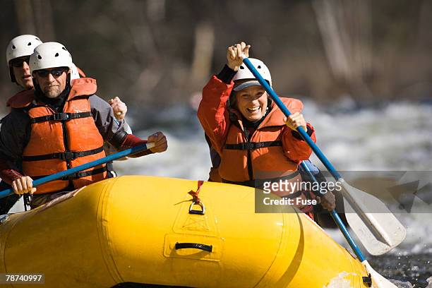 whitewater rafters paddling on river - whitewater rafting stock-fotos und bilder