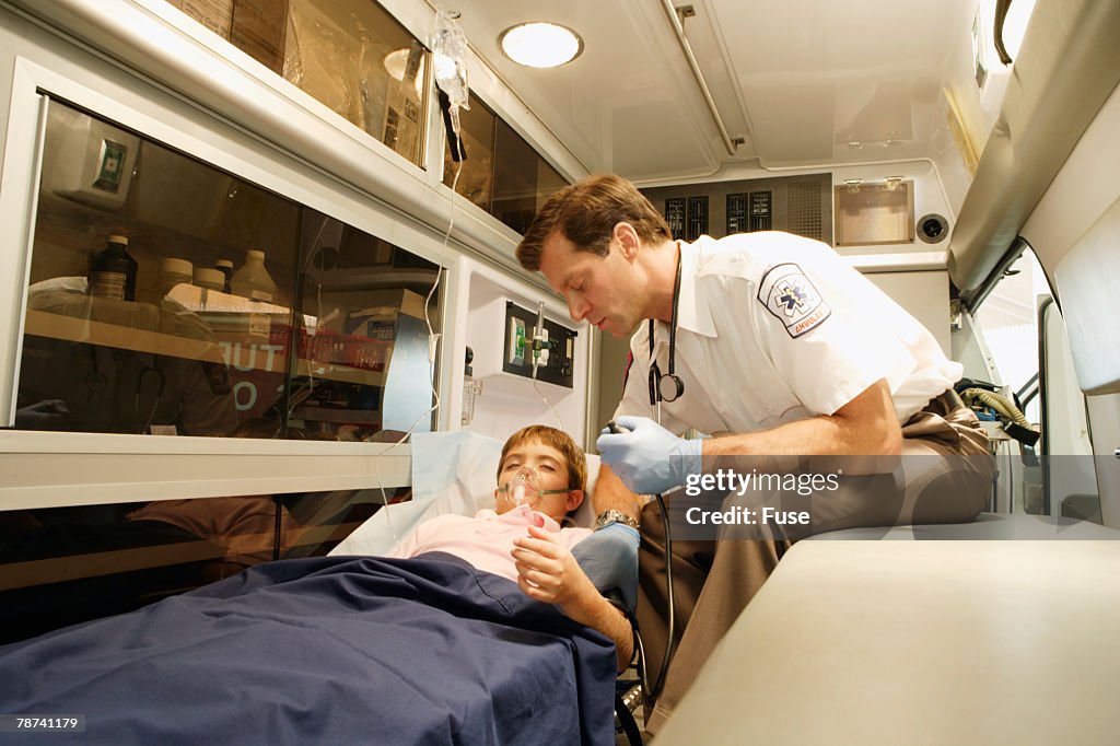 Emergency Physician Beside Boy in Ambulance