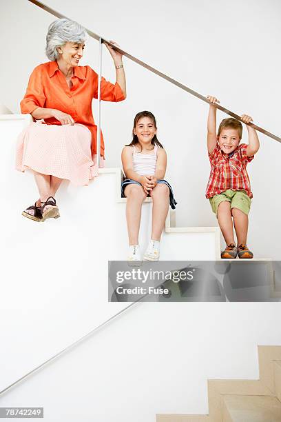 grandmother and grandchildren sitting on stairs - child running up stairs stock pictures, royalty-free photos & images