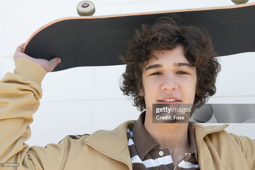 Teenage Boy Holding Skateboard