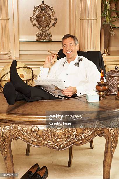 wealthy man relaxing with newspaper - cigar stock pictures, royalty-free photos & images