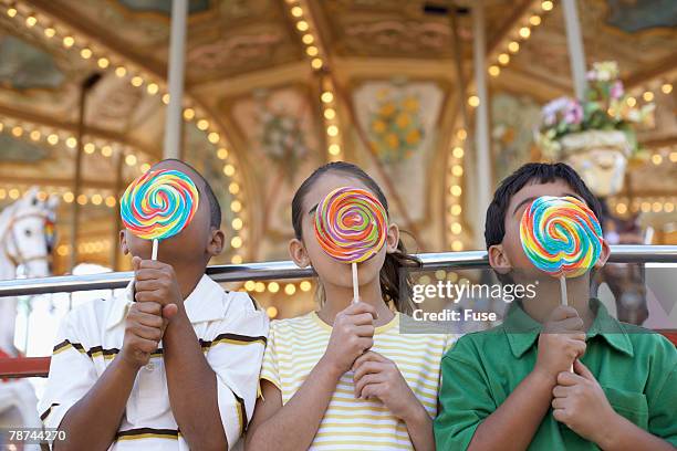 kids licking giant lollipops - lollipop stock pictures, royalty-free photos & images