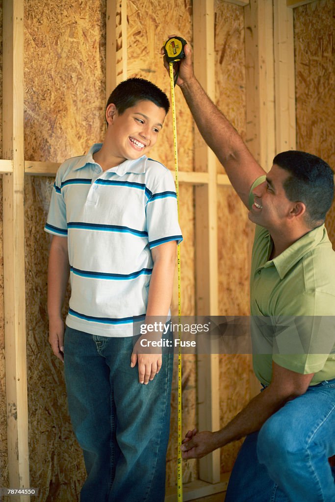Father Measuring His Son's Height