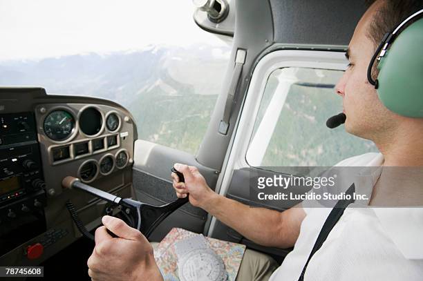 pilot flying over mountainous terrain - small plane stock pictures, royalty-free photos & images