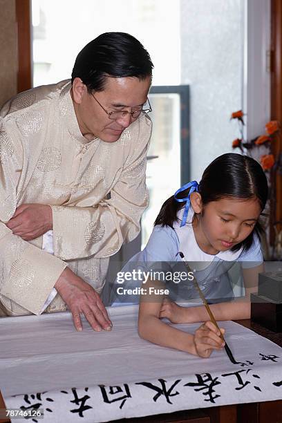 man teaching girl calligraphy - chinese language teacher stock pictures, royalty-free photos & images