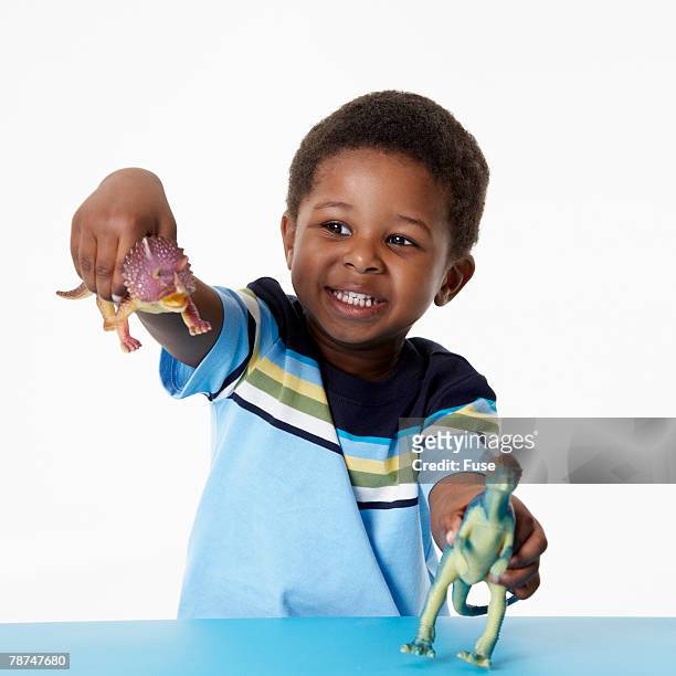 boy playing with toy dinosaurs - dinosaur toy i stock pictures, royalty-free photos & images