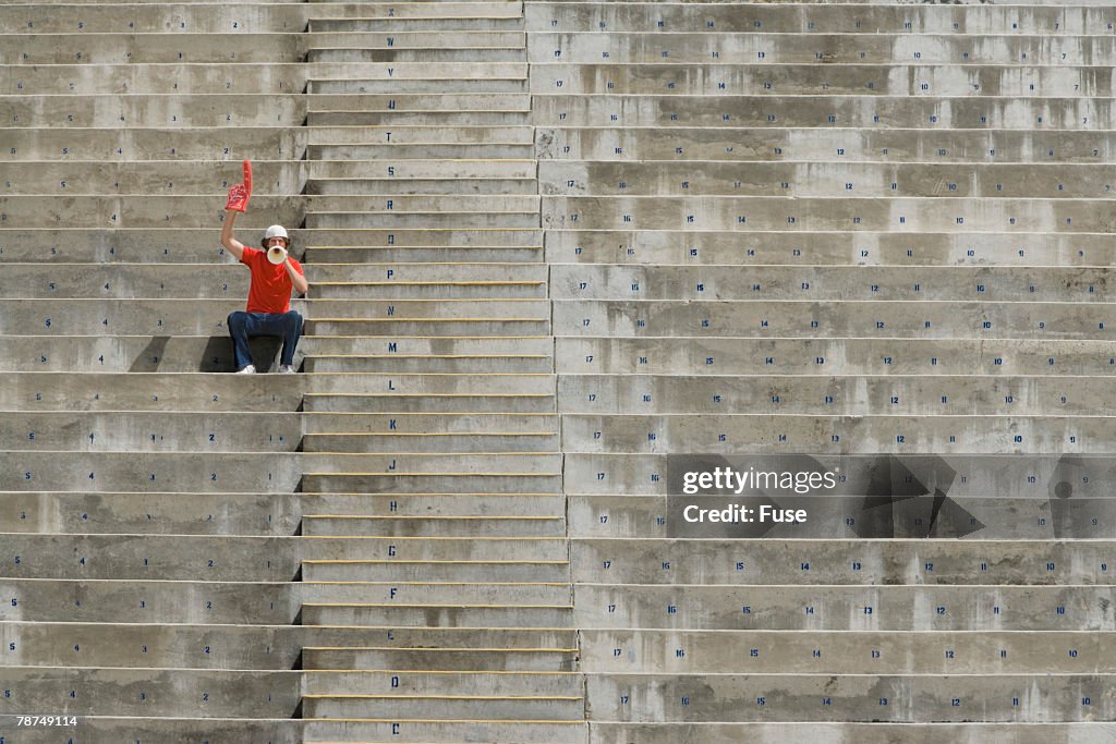 Young Man Sitting Alone in Bleachers
