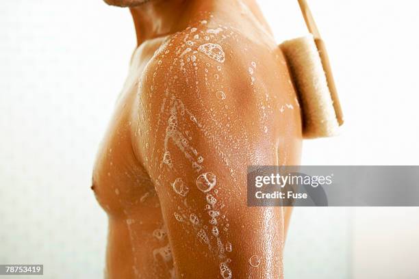 man using back scrubber - loofah fotografías e imágenes de stock