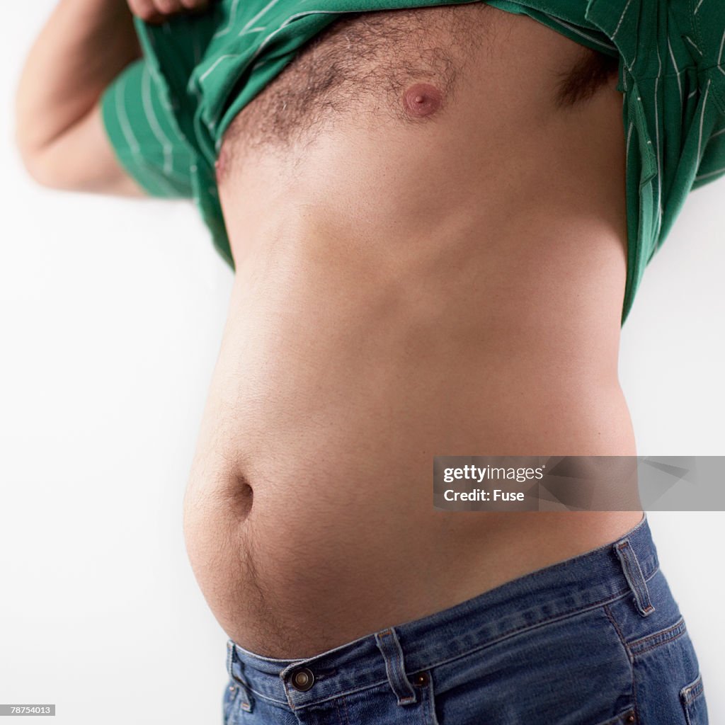Man Lifting His Shirt And Sticking Out His Belly High-Res Stock